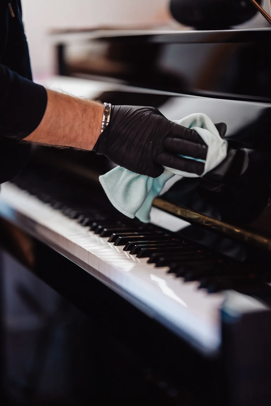 Mit einem Mikrofasertuch wird ein Klavier gereinigt